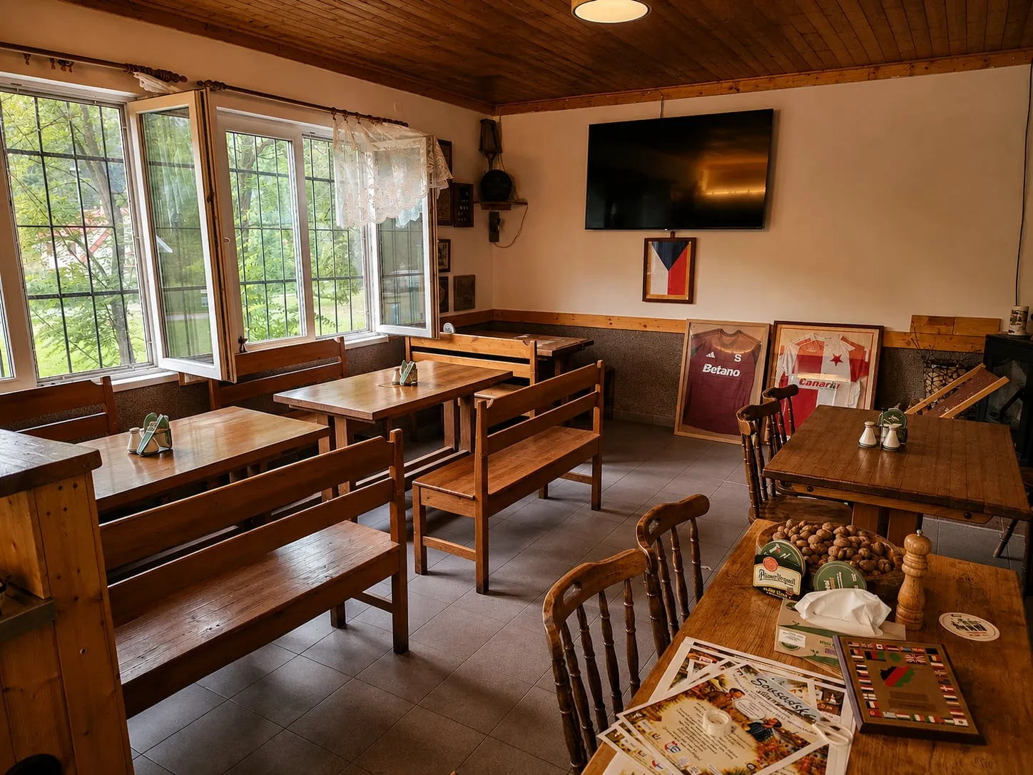 Der Saal mit Holzbänken und Tischen, bereit für eine Gesellschaft