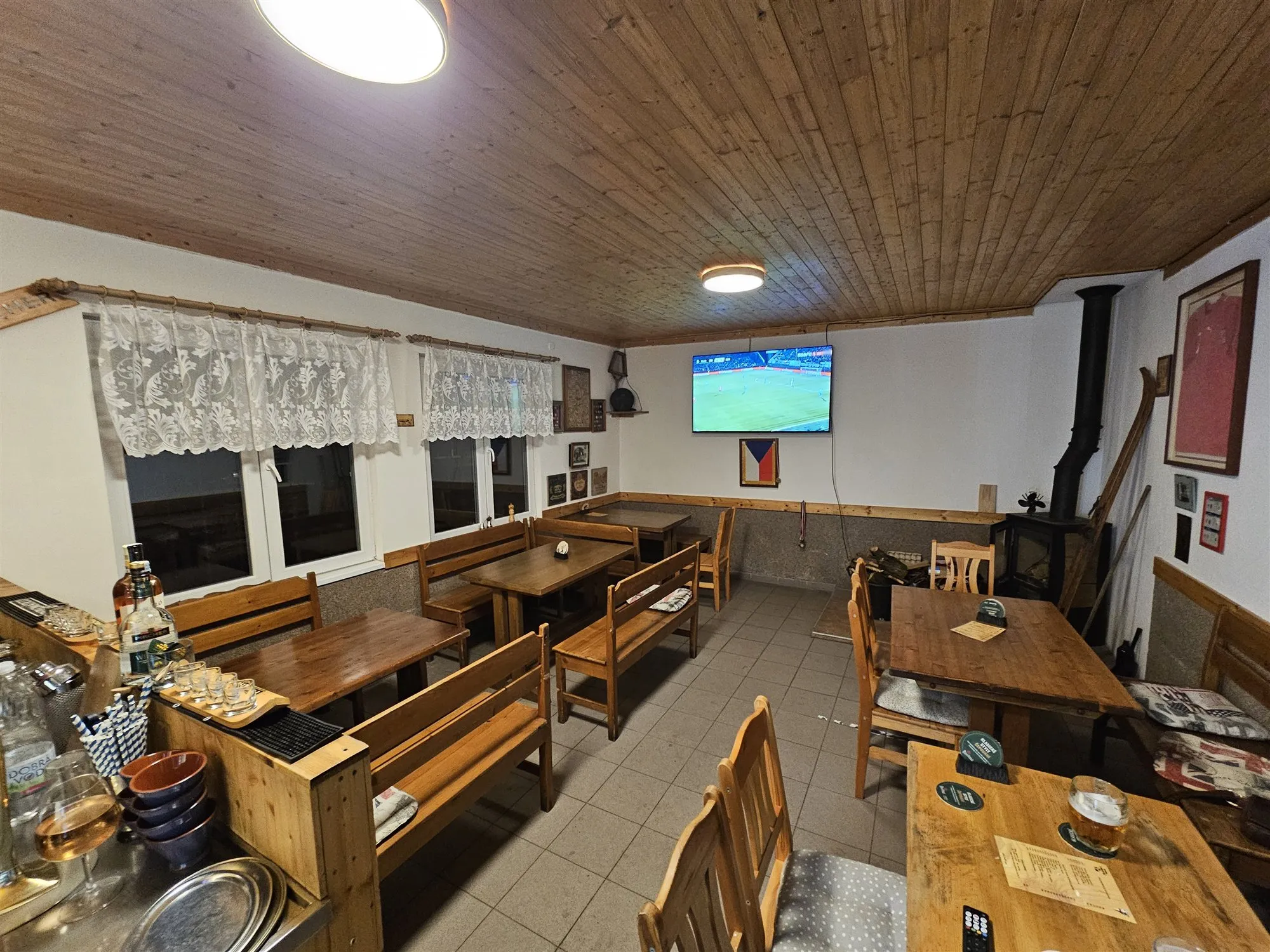 Interiér s dřevěnými lavicemi a krbovými kamny